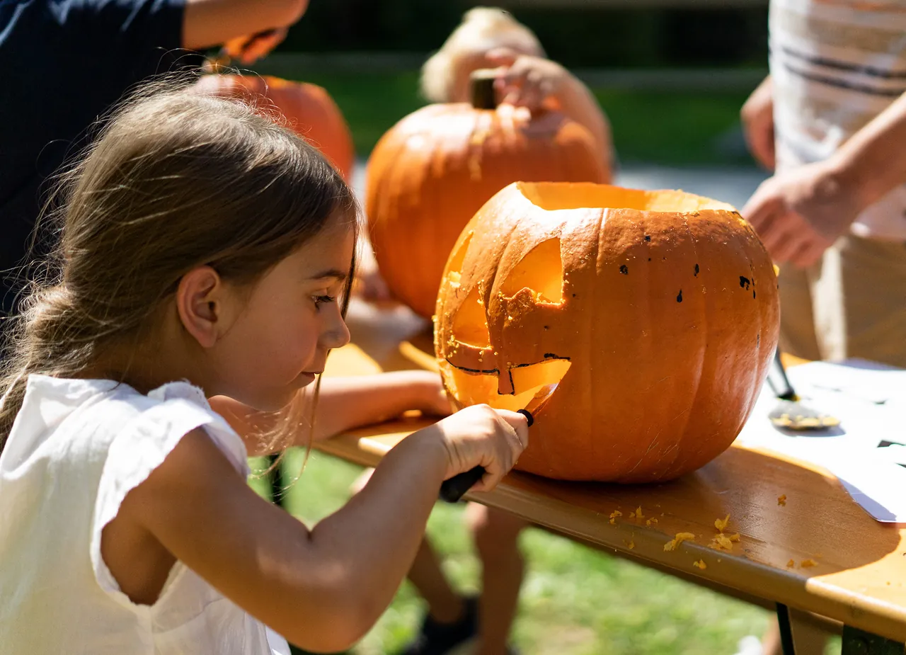 Girl carving a pumpkin at the Halloween programme of Ravensburger Spieleland